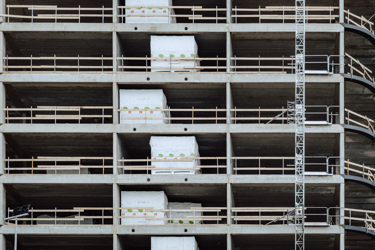 services-01 Close-up of a multi-storey building under construction, showcasing steel and concrete structure.